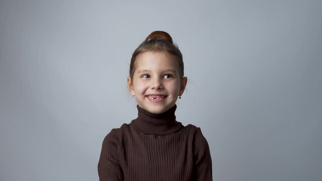 Portrait of child 6 years old girl looking at camera waving hello greeting
