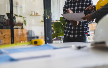 Engineers, architects and contractors discussing on the background of a real estate construction project concept image.