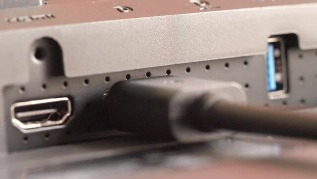 Close-up shot Hand of man insert Displayport into device. Plugging DP Port