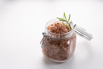 Himalayan pink salt on glass of jar isolated on white background with copyspace