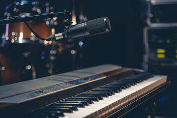 Piano and and microphone on a dark background in the interior of a music studio,