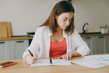 Young calm clever smart student housewife woman wear casual clothes preparing before exam study...