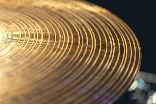 Drum cymbal close-up on a dark background.