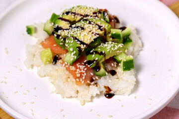 Sushi Waffle is crispy rice, made in a waffle maker, topped with shoyu salmon, crunchy cucumber