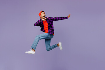 Fototapeta na wymiar Full body side view young man of African American ethnicity wears casual shirt orange hat jump high run fast with outstretched hands isolated on plain pastel purple color background studio portrait.