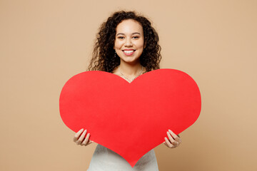 Happy beautiful fun young woman bride wear wedding dress posing hold in hands big red heart mockup isolated on plain pastel light beige background studio portrait. Ceremony celebration party concept.