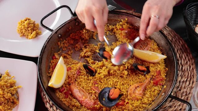 Popular dish of Spanish cuisine paella with seafood, made from rice, supplemented with saffron, squid, shrimp and mussels. . High quality 4k footage