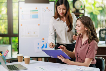 Concept of business office woman working,Businesswoman smile while working about her invesment plan with analyzing document and business investment graph data by using laptop on desk in workstation.