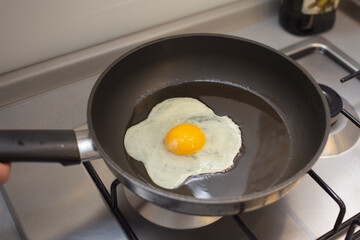 The egg is frying in the frying pan
