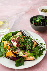 Healthy lunches, baked salmon with mixed salad and pumpkin seeds, sesame and sunflower seeds with balsamic vinegar and olive oil