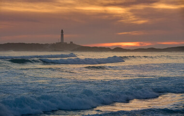 sunset at the beach of Cape Trafalgar with its lighthouse, Costa de la Luz, Andalusia, Spain