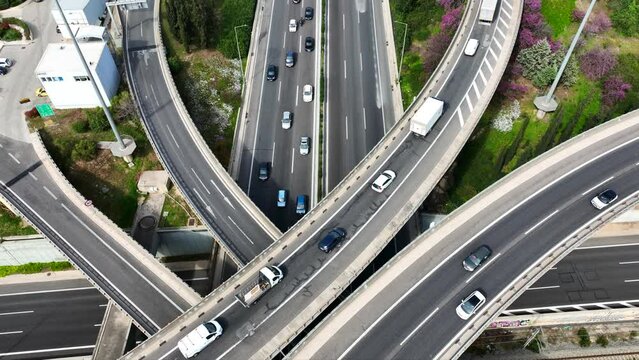 Aerial drone time lapse video of multilevel bridge highway road interchange passing near urban residential area during rush hour
