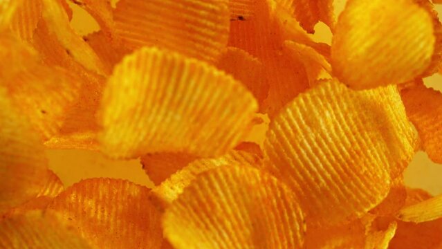 Super slow motion of flying fried potatoes chips on color gradient background. Filmed on high speed cinema camera, 1000 fps. Camera placed on high speed cine bot, tracking the target.