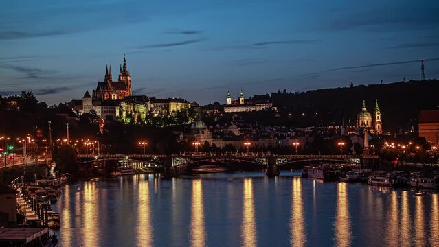 A sunset over the Vltava river in Prague with the cathedral and castle in the background. Time lapse
