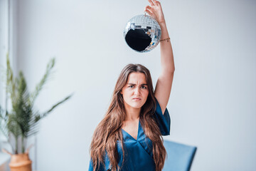 Angry businesswoman holding broken disco ball over head