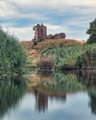 Castle at Lunan Bay, Scotland on a cool morning with reflection on the water