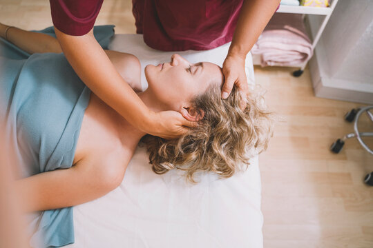 Therapist giving neck massage to customer in salon