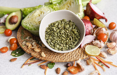 Close-up, a bowl of pumpkin seeds and other healthy foods on the kitchen table.