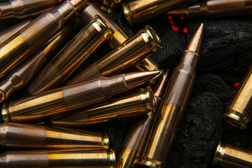Cartridges for automatic carbine caliber .223 on charcoal. Ammunition for automatic and semi-automatic rifles. Dark back.