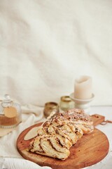 Vertical shot of a delicious nut cake with cream on a wooden plate with white background