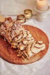 Vertical shot of a delicious nut cake with cream on a wooden plate with white background