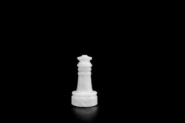 Small white marble chess piece figure isolated on the empty black background