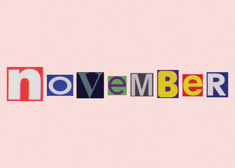 November word from cut out magazine colored letters on a light background