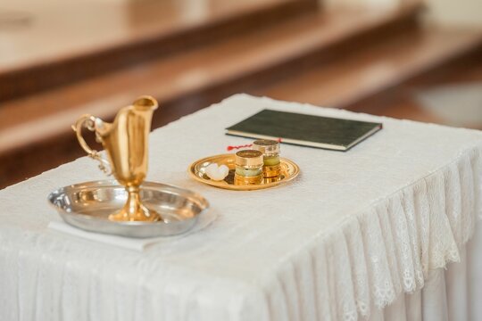 Selective focus shot of water and oil in golden containers for christening in catholic church