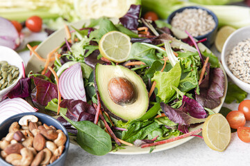 Salad of avocado and vegetables mixed greens lettuce leaves ready to eat.