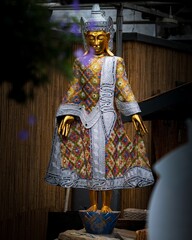 Vertical shot of a statue of a Hindu god wearing a fashionable outfit found in a garden