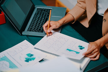 Hands of businesswoman analyzing charts with financial data