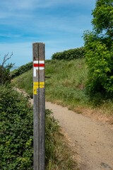 Signs directions marks of trail to Mont Saint Michel green scenery with blue sky