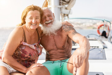 Happy senior couple on sailboat having fun during luxury ocean trip vacation - Summer, travel and pensioner concept - Soft focus on man face