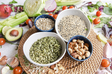 Pumpkin seeds, nuts and chia seeds and other healthy foods on the kitchen table.