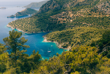 Amazing view of turquoise Coast  in beach resort in the Fethiye district - Oludeniz. Turkey. Summer landscape with mountains, green forest, deep lagoon in bright sunny day. Travel background.