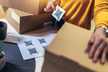 Woman affixing QR codes onto storage boxes. Concept organization, efficiency, or technology in storage management.