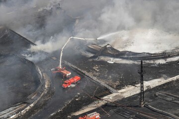 Fototapeta premium Aerial shot of firefighters putting out a fire in fuel tanks in matanzas, cuba