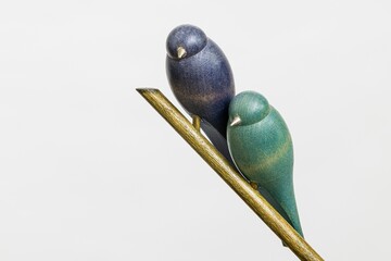 Closeup of the statue of two birds on branch with white background