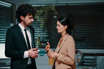 Serious business colleagues discussing project late at night