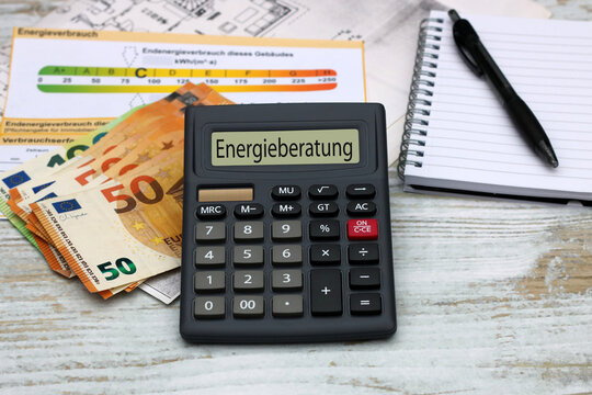 Geldscheine, Energieausweis und Taschenrechner mit dem Wort Energieberatung im Display.