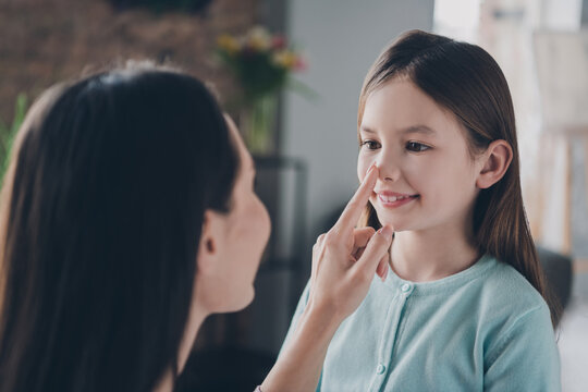 Photo of cheerful adorable mother daughter wear casual outfits playing game touching finger nose indoors house room