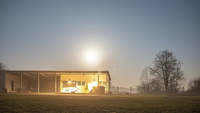 Full moon rising over a countryside home with people in a hot tub - time lapse