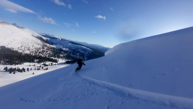 FPV aerial drone follow cam of male snowboarder dream powder open fresh snow run epic Vail Pass Colorado