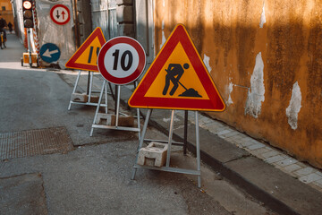 Road works sign on the road. Repair work of road signs and a bypass arrow on a background of blue...