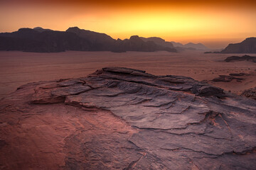 Wadi Rum w Jordanii. Pustynne formacje skalne oświetlone zachodzącym słońcem. 