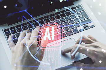 Double exposure of creative artificial Intelligence abbreviation with hand typing on computer...