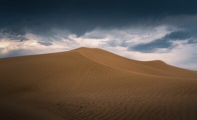 Beautiful shot of sand dune landscape with dark clouds in the desert