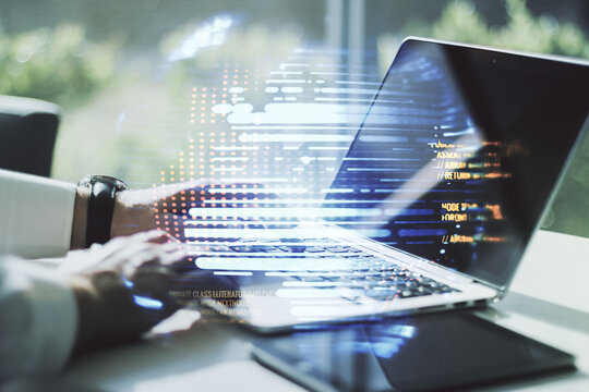 Double exposure of abstract programming language hologram with world map and hands typing on laptop on background, research and development concept