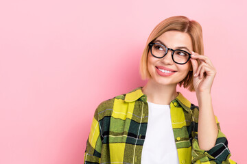 Photo of positive minded girl hand touch glasses beaming smile look empty space isolated on pink color background