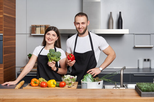 Young couple coocking salad in the kitchen